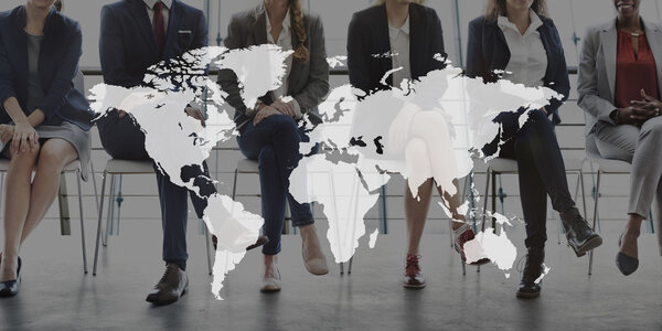 Рабочие сидят на стульях и на карте мира
