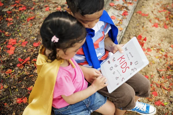 Broer en zus spelen met tablet — Stockfoto