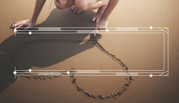 Жінка малює символ серця на пляжі — стокове фото