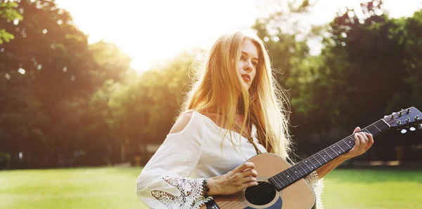 Blondes Mädchen spielt Akustikgitarre — Stockfoto