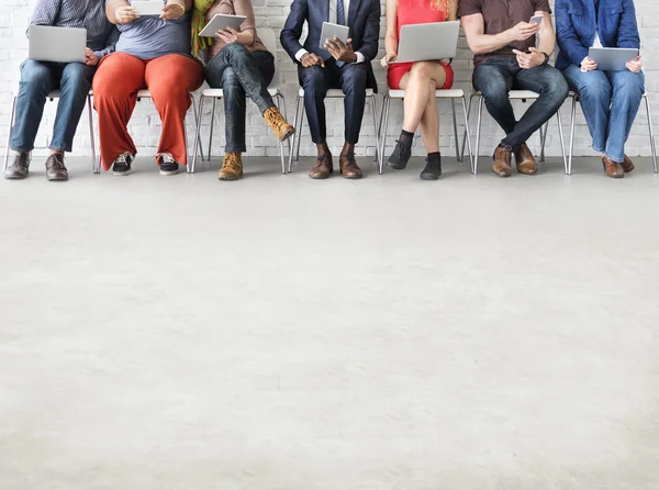 Mensen zit op stoelen met digitale apparaten — Stockfoto