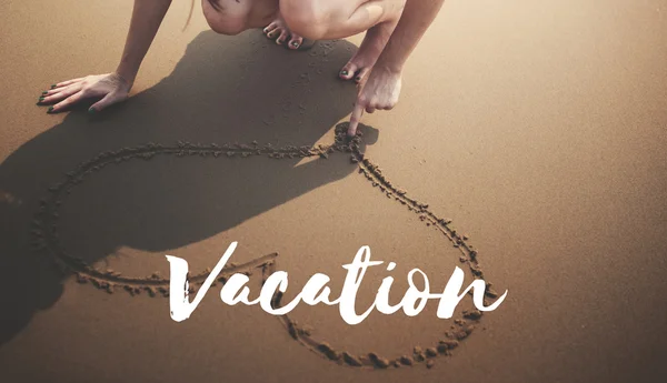 Woman drawing heart symbol on beach — Stock Photo, Image