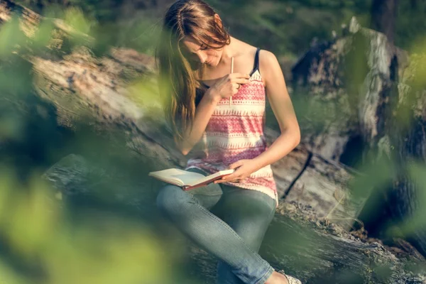 Frau schreibt Notizen in der Natur — Stockfoto