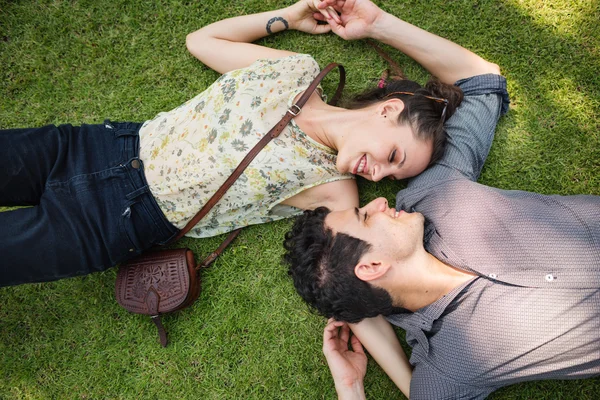 Doce casal deitado na grama — Fotografia de Stock