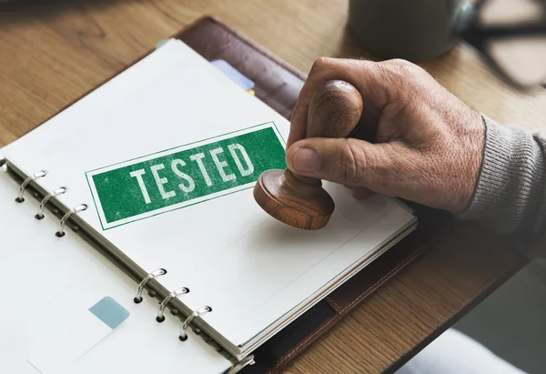 Carimbo no caderno com Testado — Fotografia de Stock