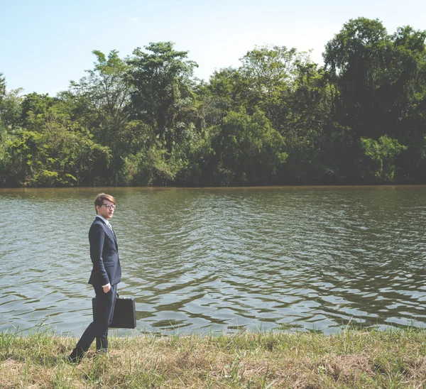 Empresario con maletín en el río — Foto de Stock