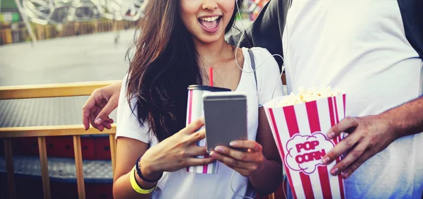 Coppia utilizzando cellulare nel parco divertimenti — Foto Stock