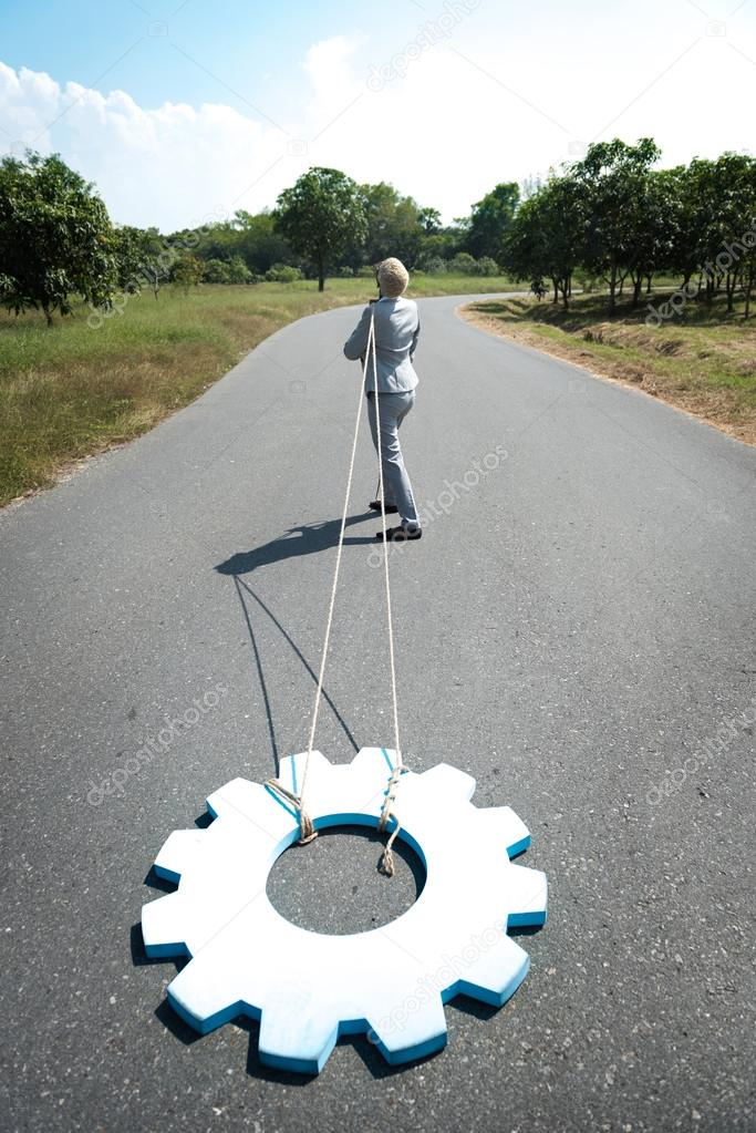  businesswoman pulls gear wheel