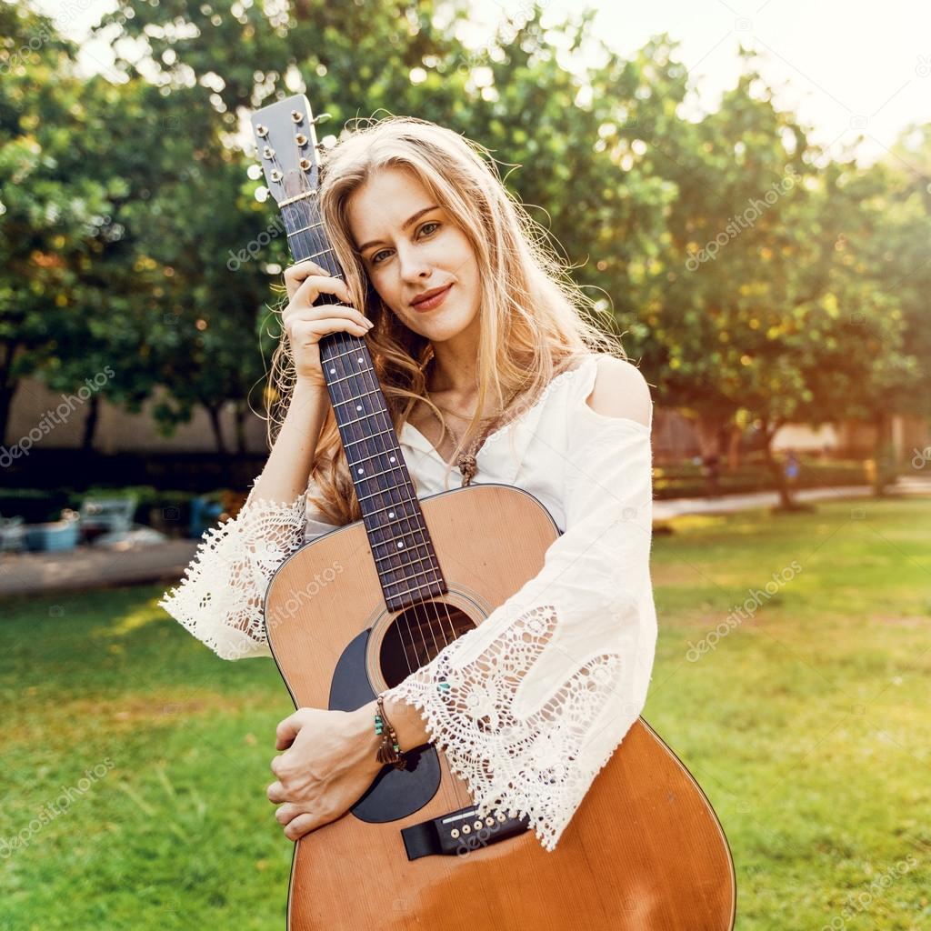 Blonde woman hugging acoustic Guitar 