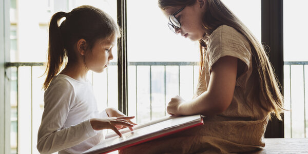 Sisters reading book together