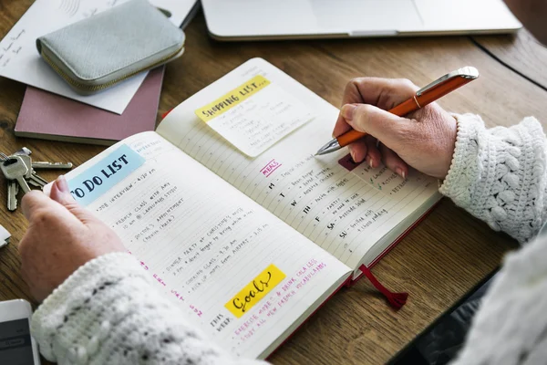 Person writing notes in diary — Stock Photo, Image