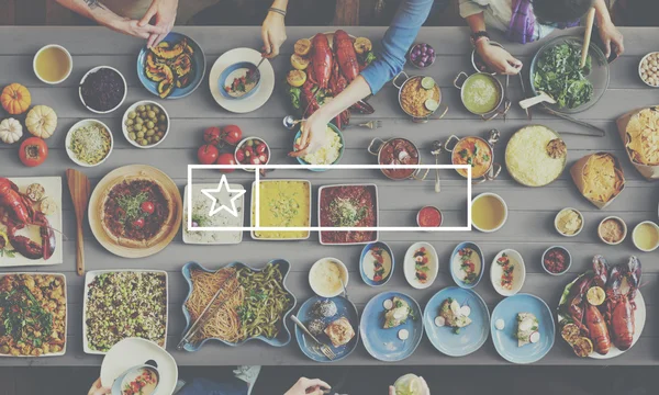 Vrienden eten aan de tafel met verschillende voedsel — Stockfoto