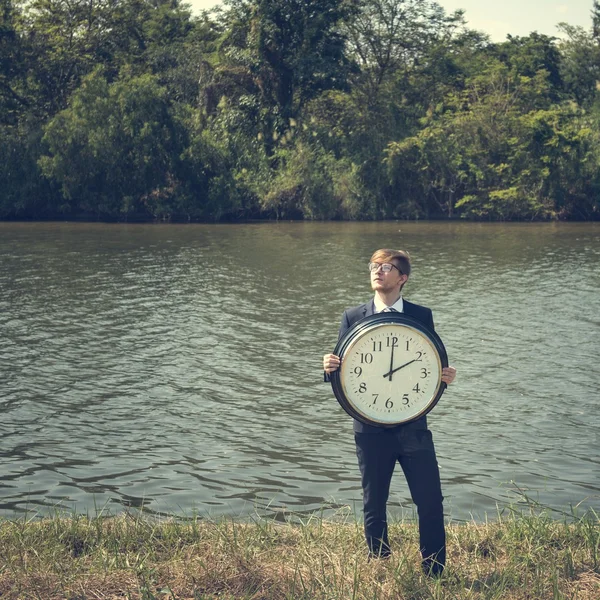 Empresario sosteniendo gran reloj — Foto de Stock