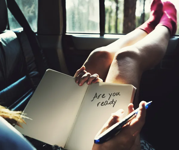 日記を保持している、車で横になっている女性 — ストック写真