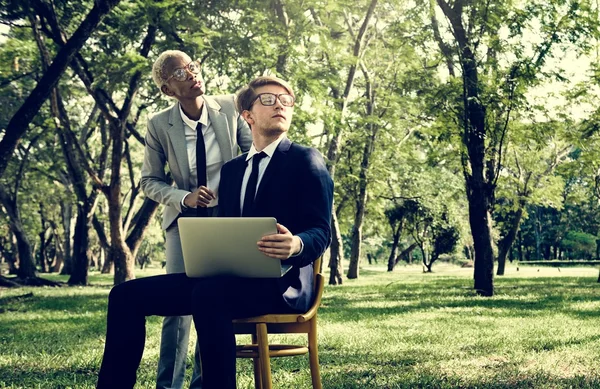 Colleagues with laptop at park — Stock Photo, Image