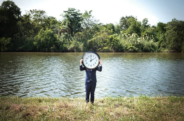 Empresario sosteniendo gran reloj — Foto de Stock