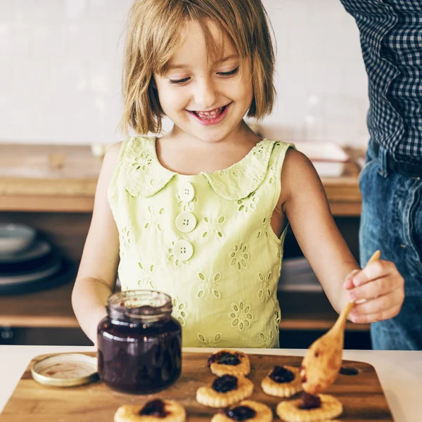 Ragazza che cucina biscotti fatti in casa con marmellata — Foto Stock