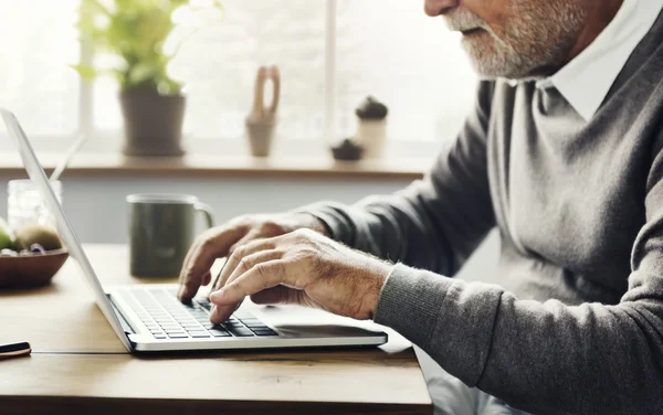 Homme âgé utilisant un ordinateur portable numérique — Photo
