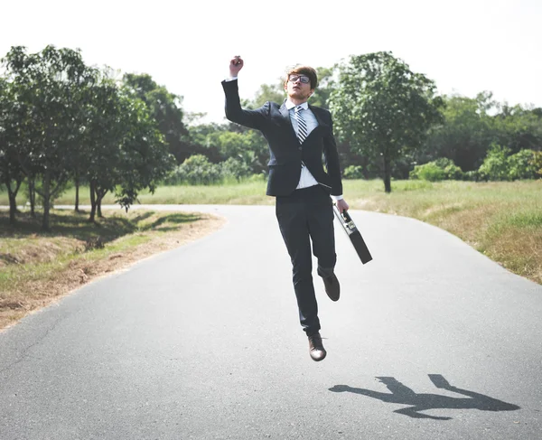 Бізнесмен на відкритому повітрі стрибає з футляром — стокове фото