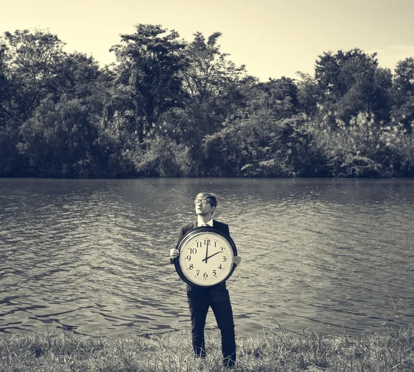 Empresario sosteniendo gran reloj — Foto de Stock