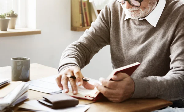 Senior Man schrijven nota's in dagboek — Stockfoto