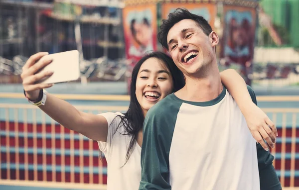 Pareja haciendo selfie en parque de atracciones —  Fotos de Stock