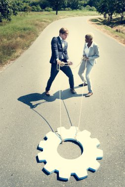 İş adamı ve iş kadını yolda Dişli çark çekin