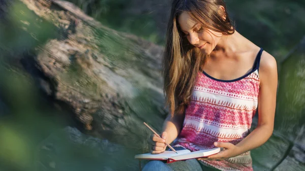 Woman writing notes in nature — Stock Photo, Image