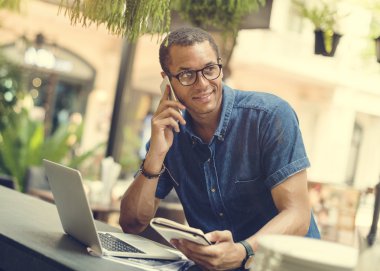 Cep telefonunuzda konuşuyor ve dizüstü bilgisayar kullanarak bir adam