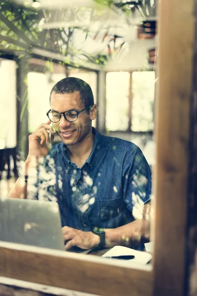 Mann telefoniert mit Handy und Laptop — Stockfoto