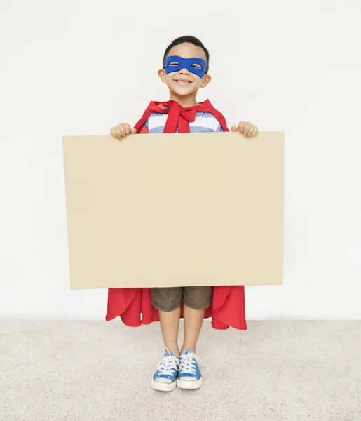 Rapaz super-herói com papelão nas mãos — Fotografia de Stock