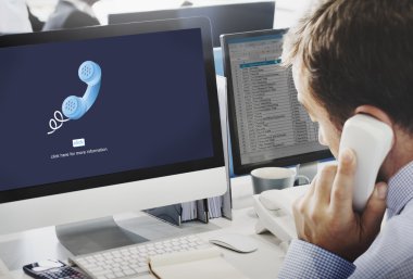telefon ile bilgisayar üzerinde çalışan iş adamı