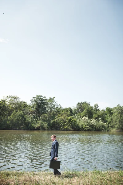 Empresario con maletín en el río , — Foto de Stock