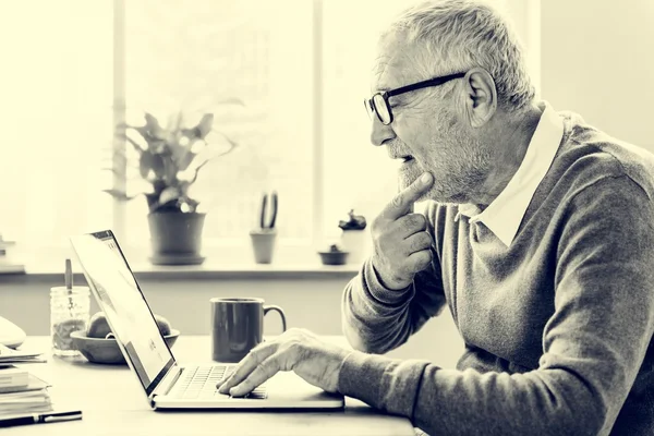 Homme âgé utilisant un ordinateur portable numérique — Photo