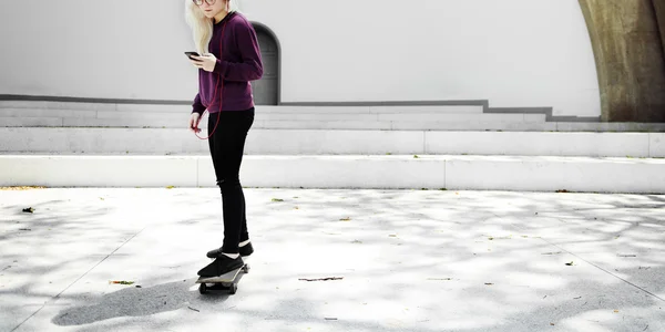 Blonďatá dívka jízda na skateboardu — Stock fotografie