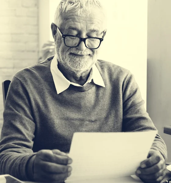 Homme âgé tenant un document papier — Photo