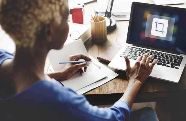 Женщина работает на ноутбуке с иконкой — стоковое фото