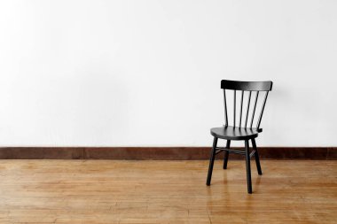 Beyaz duvara yaslanmış bir sandalye.