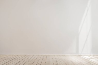 Ahşap zemini olan beyaz beton bir duvar.