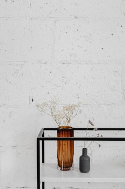 Beyaz bir duvarın yanında vazoda çiçek