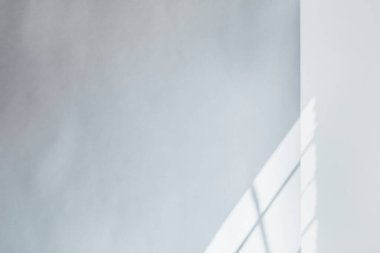 Beyaz bir duvar arkaplanındaki pencereden gelen ışık