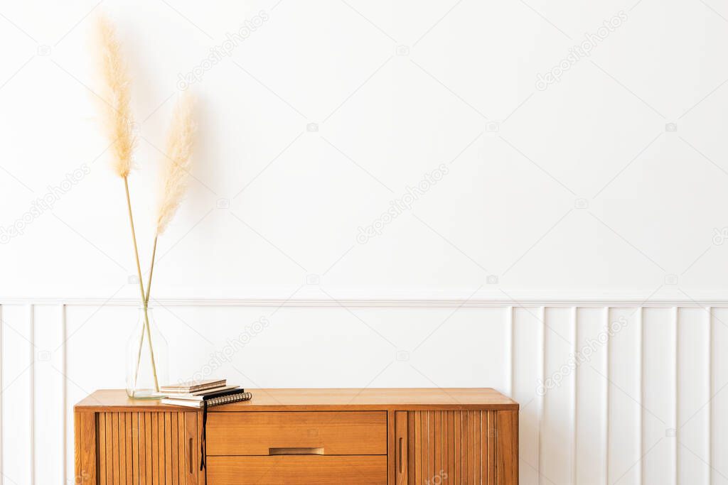 Pampas grass in a vase on a wooden sideboard table