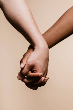 Siyah el beyaz eli tutuyor.