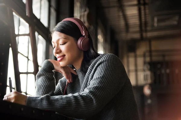 Asiatin Hört Musik Über Kopfhörer Und Schreibt Notizbuch — Stockfoto