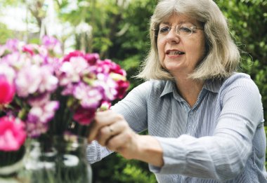 Yaşlı beyaz kadın çiçek hobisi