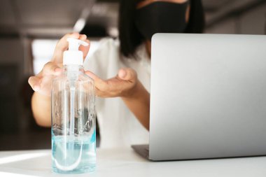 Coronavirüs bulaşmasını önlemek için el dezenfektanı jeliyle el temizleyen kadın.