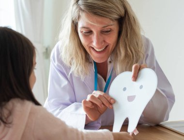 Diş hekimi öğretmek küçük kız nasıl fırça dişler için