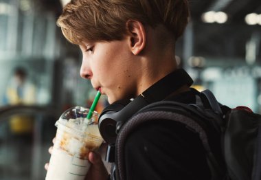 Genç Kafkasyalı gezgin havaalanında içki içiyor.