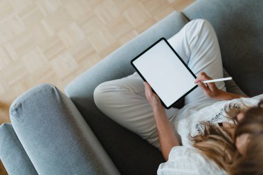 Coronavirus karantinası sırasında dijital tabletle stil kullanan bir kadın.