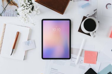 Dağınık bir masadaki dijital tabletin havadan görüntüsü